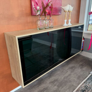 Hängevitrine in Eiche Dekor mit dunkler Glasfront an Wand montiert